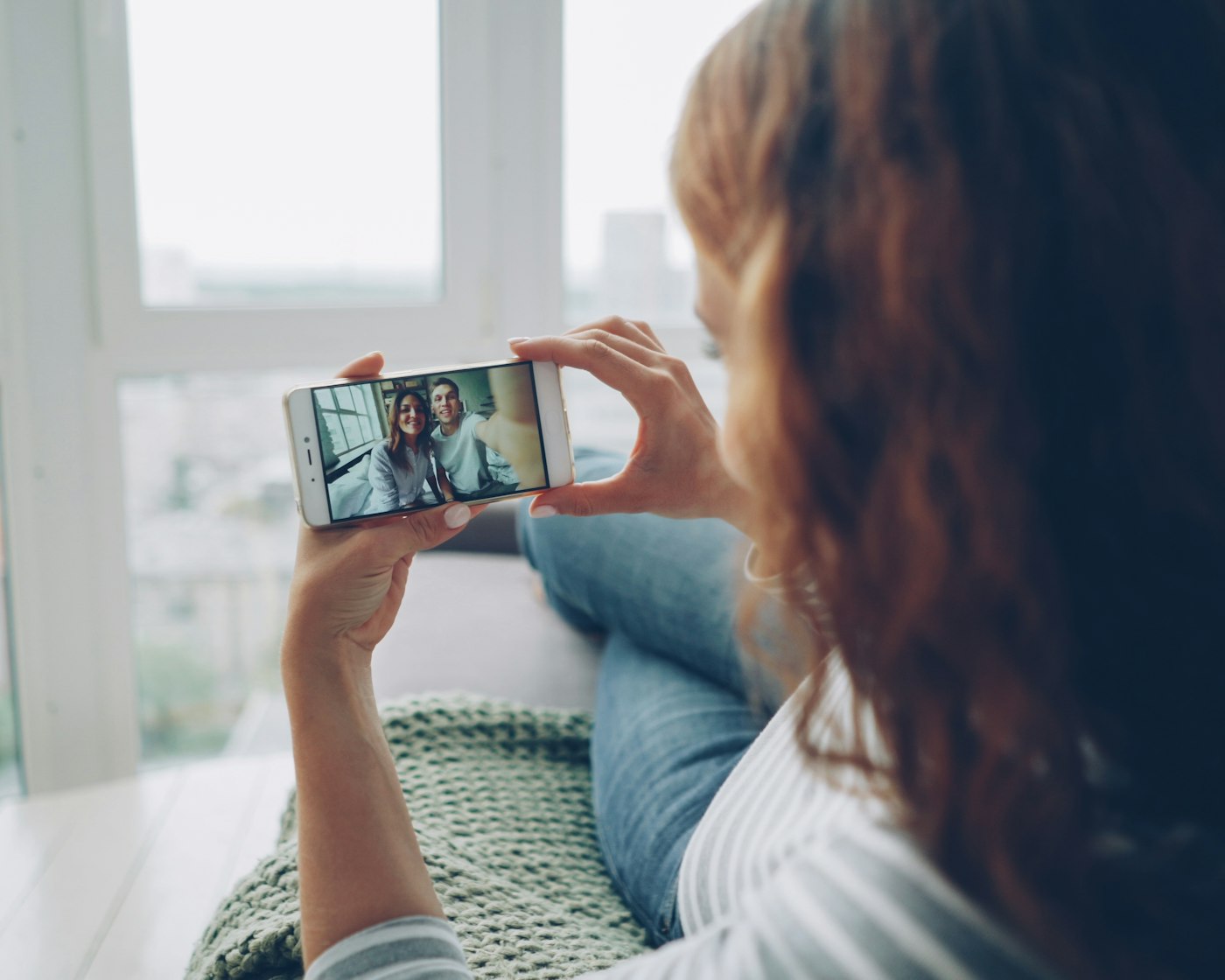 A woman on a video call to people back home from a bright, unfamiliar flat